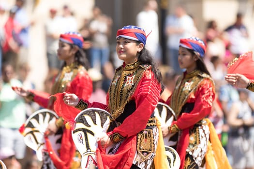 Washington, D.C., USA - April 14, 2018 People from Indonesia wearing traditional clothing walking down the street in the 2018 National Cherry Blossom Parade
