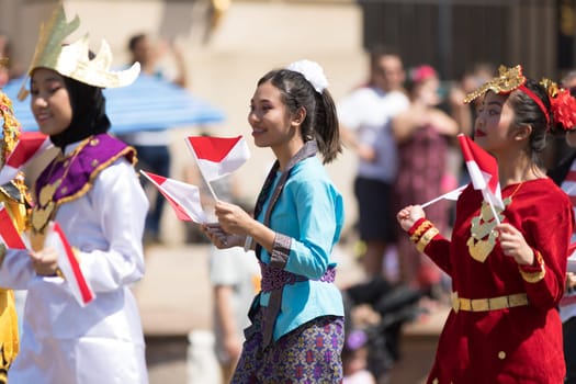 Washington, D.C., USA - April 14, 2018 People from Indonesia wearing traditional clothing walking down the street in the 2018 National Cherry Blossom Parade