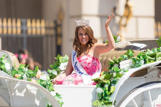 Washington, D.C., USA - April 14, 2018 Miss America on a white carriage with flowers going down the road in the 2018 National Cherry Blossom Parade