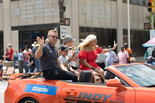 Indianapolis, Indiana, USA - May 26, 2018, Indycar driver Ed Carpenter and his family on a car going down the road at the Indy 500 Parade