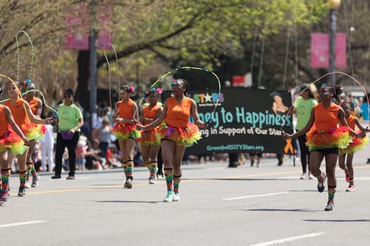 Washington, D.C., USA - April 14, 2018 Students wearing colorful skirts jumping ropes  in the 2018 National Cherry Blossom Parade