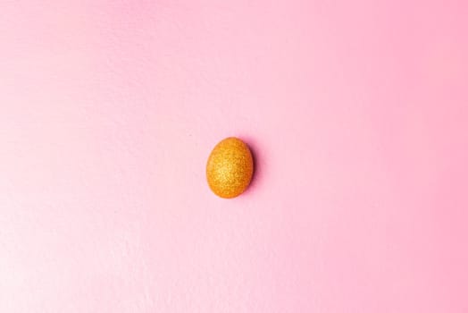 Easter egg with glitter yellow color on pink color background. Happy Easter
