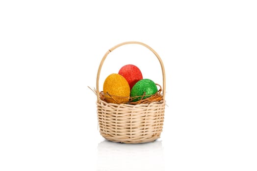Colorful easter eggs with glitter in the nest on wooden basket isolated over white background. Happy Easter