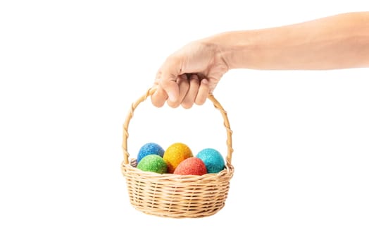 Human hands holding wooden basket with colorful easter eggs isolated over white background. Happy Easter