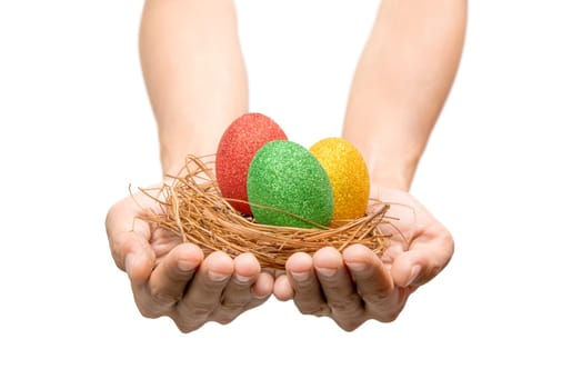 Human hands holding nest with colorful easter eggs isolated over white background. Happy Easter