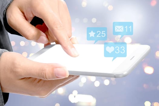 Business woman touching the mobile phone screen with notification of message, likes and important things over blurred light background