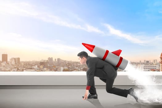 Young asian businessman on the rooftop with rocket ready to fly. Business concept