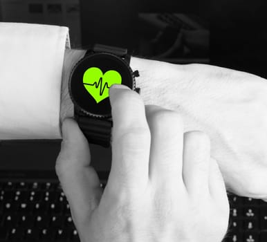 Black smartwatch isolated on a black background, heartbeat