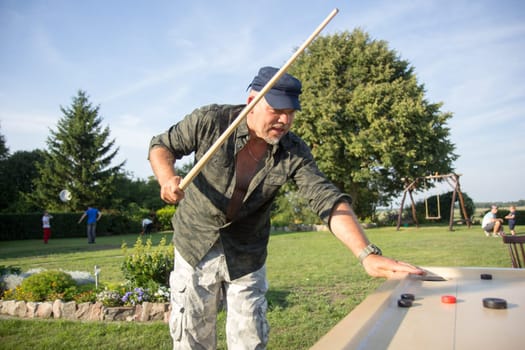 Man playing Novuss in outdoors. Novuss is a national sport in Latvia similar to pocket billiards or pool.