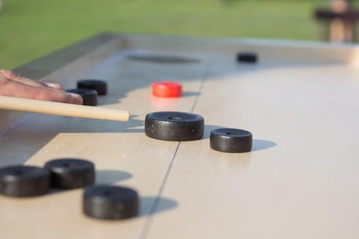Man playing Novuss in outdoors. Novuss is a national sport in Latvia similar to pocket billiards or pool.