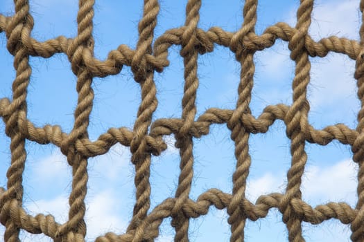 Net from large ropes against blue sky