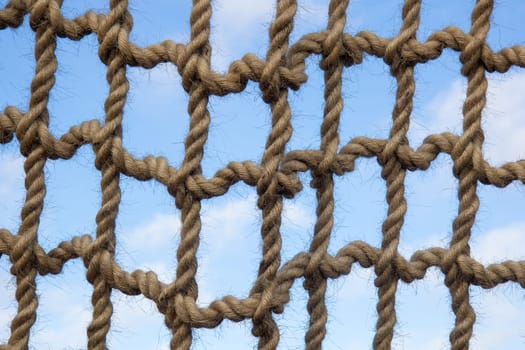 Net from large ropes against blue sky