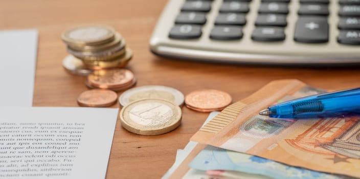 Calculator with euro bills and coin stacks