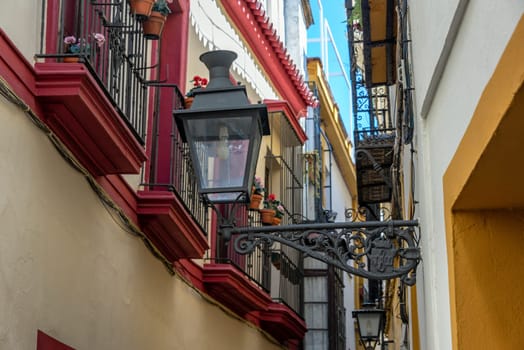 Old street light in a narrow street in Seville, Spain
