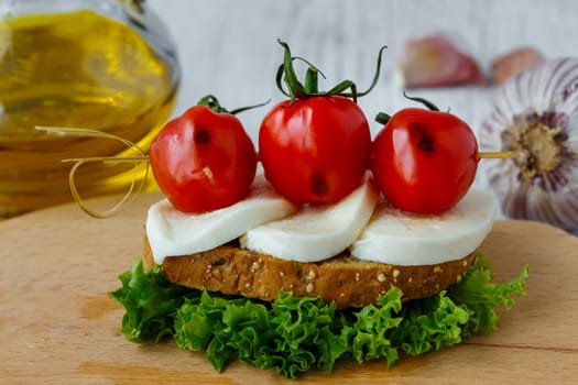 Bruschetta with mozzarella and cherry tomatoes on a sheet of lettuce