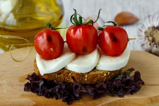Bruschetta with mozzarella and cherry tomatoes on a sheet of lettuce