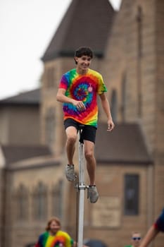Peru, Indiana, USA - July 21, 2018 Men and women riding unicycles under the rain at the Circus City Festival Parade
