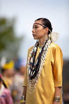 Milwaukee, Wisconsin, USA - September 8, 2018 The Indian Summer Festival Young woman wearing traditional native american clothing at the pow wow competition.