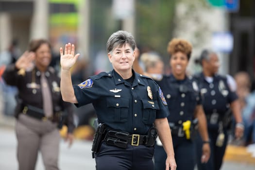Indianapolis, Indiana, USA - September 22, 2018: The Circle City Classic Parade, Female police officers going down the road waving at spectators