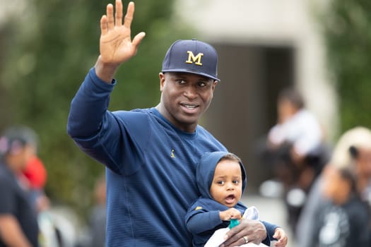 Indianapolis, Indiana, USA - September 22, 2018: The Circle City Classic Parade, Marlin Jackson former Philadelphia Eagles NFL Team player, waves at people while holding his son, going down the street on a car