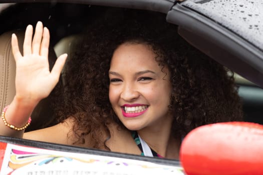 Peru, Indiana, USA - July 21, 2018 Young african american woman waves and smile at the camera at the Circus City Festival Parade