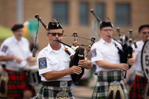 Peru, Indiana, USA - July 21, 2018 Men from the Indianapolis 500 Gordon Pipers Horse Shoe Pipes and Drums playing bagpipes at the Circus City Festival Parade