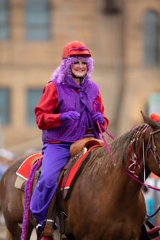 Peru, Indiana, USA - July 21, 2018 Woman dress up as a clown riding a horse at the Circus City Festival Parade