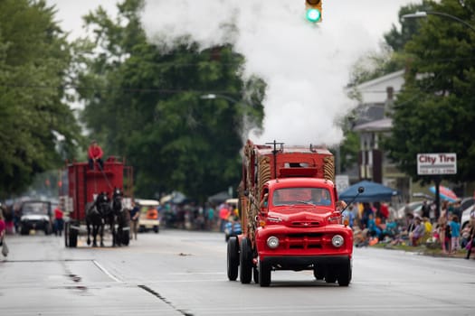 Peru, Indiana, USA - July 21, 2018 Old classic red turck creating steam going down the road at the Circus City Festival Parade