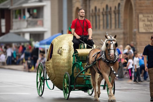 Peru, Indiana, USA - July 21, 2018 Horse pulling a wagon in the shape of an apple at the Circus City Festival Parade