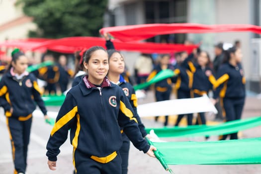 Matamoros, Tamaulipas, Mexico - November 20, 2018: The November 20 Parade, Female students carry large ribbons with the colors of the mexican flag