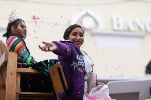 Matamoros, Tamaulipas, Mexico - November 20, 2018: The November 20 Parade, Young woman wearing traditional mexican clothing throwing confetti at the espectators
