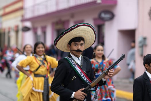 Matamoros, Tamaulipas, Mexico - November 20, 2018: The November 20 Parade, Young Boy wearing traditional mexican clothing holding a toy rifle during the parade
