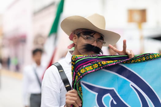 Matamoros, Tamaulipas, Mexico - November 20, 2018: The November 20 Parade, Young man wearing traditional mexican clothing with a sombrero giving the peace sign