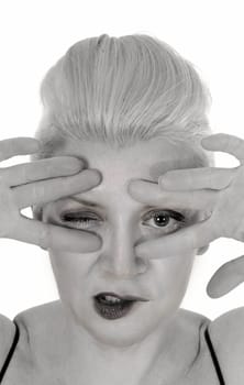 A close up portrait image of a middle age woman holding her finger.over her face, looking trough, isolated for white background.