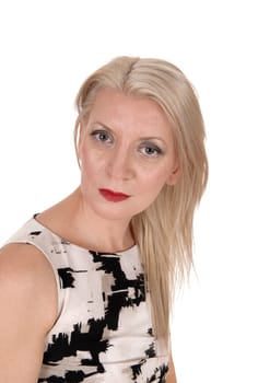 A beautiful middle age blond woman in a portrait image looking into.the camera in a summer dress, isolated for white background.