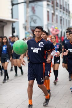 Matamoros, Tamaulipas, Mexico - November 20, 2018: The November 20 Parade, Young men playing Soccer with a green ball during the parade