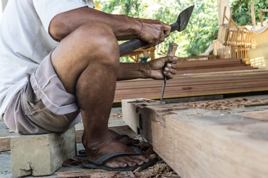 Close up of warn hands of carpenter working with manual tools in traditional carpentry shop in a third world country. Heavy labour intensive manual work.