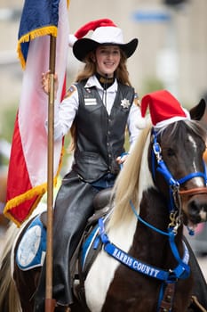 Houston, Texas, USA - November 22, 2018 The H-E-B Thanksgiving Day Parade, Woman with a Sheriff badge and Uniform riding a horse with a christmas hat