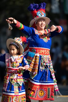 Washington, D.C., USA - September 29, 2018: The Fiesta DC Parade, woman and girl from bolivia wearing traditional clothing dancing