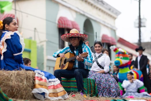 Matamoros, Tamaulipas, Mexico - November 20, 2018: The November 20 Parade, Young mexican man playing the guitar on a float