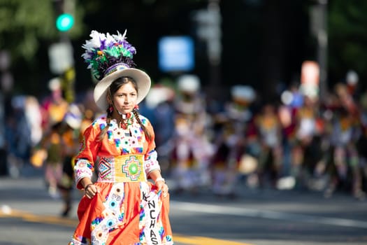 Washington, D.C., USA - September 29, 2018: The Fiesta DC Parade, Young Bolivian girl wearing traditional clothing going down the street during the parade