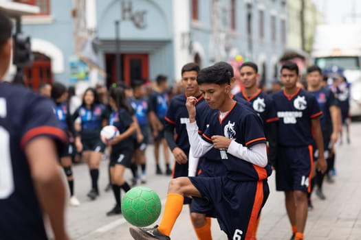 Matamoros, Tamaulipas, Mexico - November 20, 2018: The November 20 Parade, Young men playing Soccer with a green ball during the parade