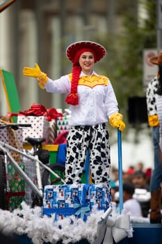 Houston, Texas, USA - November 22, 2018 The H-E-B Thanksgiving Day Parade, Woman on a float waving at people dress up as Jessie Toy Story Character