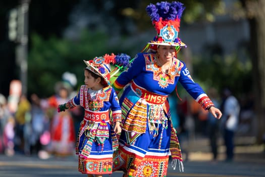 Washington, D.C., USA - September 29, 2018: The Fiesta DC Parade, woman and girl from bolivia wearing traditional clothing dancing