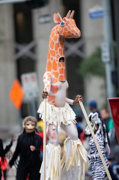 Houston, Texas, USA - November 22, 2018 The H-E-B Thanksgiving Day Parade, African American woman dress up as a giraffe on Stilts, dancing at the parade