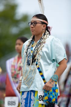 Milwaukee, Wisconsin, USA - September 8, 2018 The Indian Summer Festival Young woman wearing traditional native american clothing at the pow wow competition.