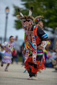 Milwaukee, Wisconsin, USA - September 8, 2018 The Indian Summer Festival, Man wearing traditional native american clothing, dancing at the pow wow competition.