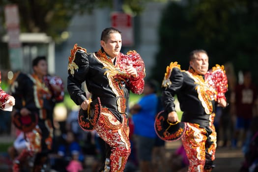 Washington, D.C., USA - September 29, 2018: The Fiesta DC Parade, Bolivian men wearing traditional clothing performing a traditional Bolivian dance