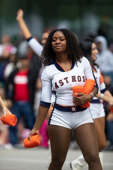 Houston, Texas, USA - November 22, 2018 The H-E-B Thanksgiving Day Parade, Cheerleaders from the Astros Baseball team giving spectators free shirts