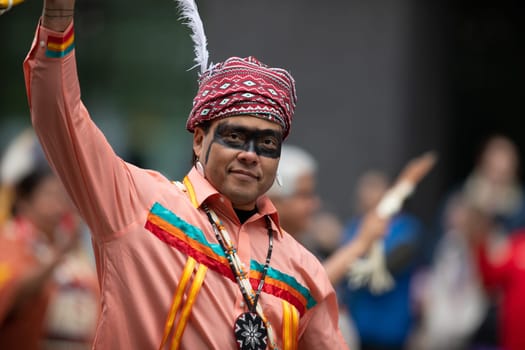 Houston, Texas, USA - November 22, 2018 The H-E-B Thanksgiving Day Parade, Native American man wearing traditional clothing waves at the camera